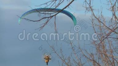 日落时分，一个人在城市里用马达驾驶<strong>滑翔伞</strong>。 夏季