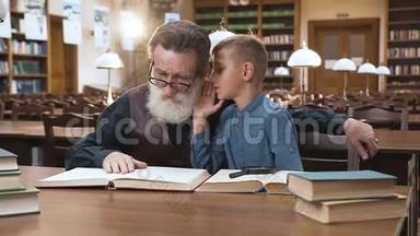 英俊的金发男孩对坐在图书馆里的有经验的<strong>老爷爷</strong>低语