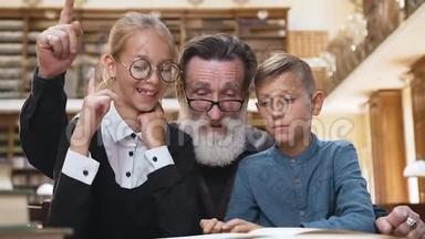 英俊的长胡子老人看书，举起手指，让他十几岁的孙子们明白了这本书的内涵