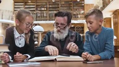 聪明的老人，梳着整齐的胡须，坐在图书馆的桌子旁，和他可爱的少年一起看书