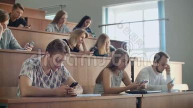大量的学生看着智能手机的屏幕，在现实生活中不交流，只写信息