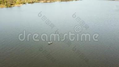 空中无人机在湖上的一艘小渔船上向渔民射击。 美丽的夏日风景湖.. 鸟瞰图