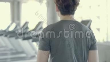 英俊的亚洲年轻人在健身房步行到跑步机，亚洲男人在跑步机上锻炼有氧运动以促进健康