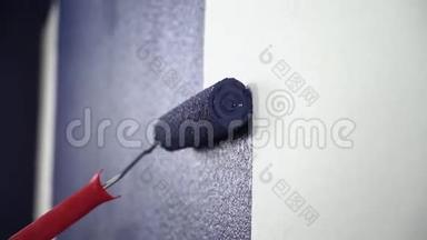 封闭靠垫将白色墙壁涂成蓝色。 <strong>油漆</strong>用的白色壁纸是用特殊的<strong>油漆</strong>滚筒<strong>油漆</strong>的。