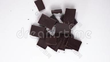 打开的巧克力片的俯视图。 黑巧克力旋转，旋转在白色的桌子上。 甜点在桌子上。