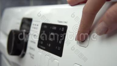 一个年轻的女人打开洗衣机。 一个女人把她的手通过洗衣机打开。 双手合拢