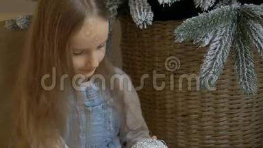 小女孩正在用大银宝装饰圣诞树。 可爱的金发女孩准备<strong>回家</strong>过<strong>圣诞节</strong>