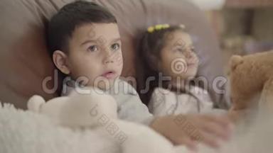 一个可爱的中东男孩和他的妹妹坐在教练和玩玩具的特写脸。 幼儿开支