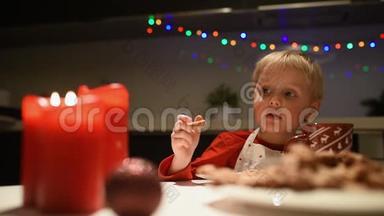 可爱的小男孩在假期吃自制的饼干，喝热可可。 圣诞节和新年有孩子。