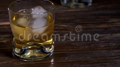 冰块和金色麦芽威士忌一起倒入玻璃杯中