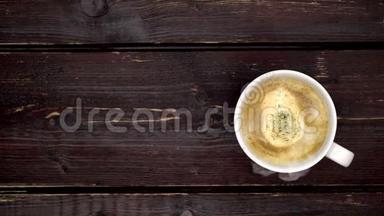 旧木桌上的热咖啡杯。 一滴蒸汽从一杯热咖啡中涌出。 商务及饮品概念