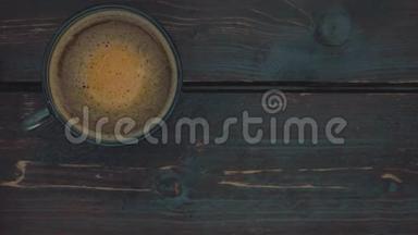 咖啡泡沫在玻璃杯中与咖啡一起旋转。 桌子的深褐色表面。 从上<strong>往下</strong>看。 慢动作