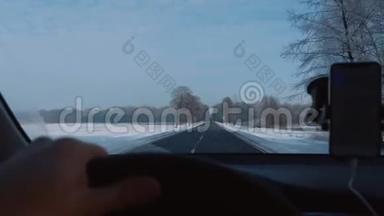 POV特写镜头，司机驾驶汽车在华丽的冬季<strong>道路</strong>与智能手机<strong>导航</strong>应用程序慢动作。