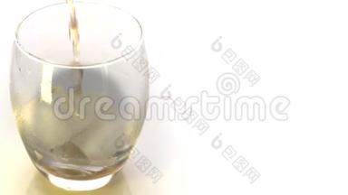 金色威士忌倒入玻璃。 将威士忌或白兰地倒入带有白色背景冰块的玻璃杯中