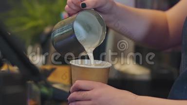 女咖啡师把<strong>热牛奶</strong>和泡沫倒入纸玻璃中