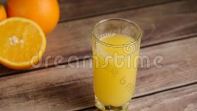 冰块上的俯视图落在<strong>一杯</strong>橙汁或<strong>柠檬水</strong>和橘子放在木桌上。