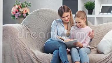 有吸引力的快乐家庭阅读书籍，享受周末一<strong>起坐</strong>在舒适的沙发上