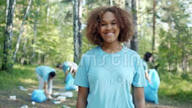 穿着志愿者制服的快乐非裔美国女孩在被污染的森林中的肖像