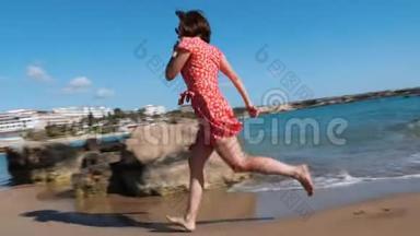 年轻的黑发女孩穿着红色短裙沿着海岸奔跑。 高加索辣妹在海上。 可爱的女孩在沙滩上奔跑