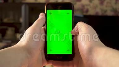 那个人用电话。 手动滑动智能手机与绿色屏幕。 铬钥匙。