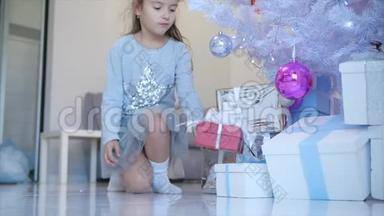 小天使女孩完美微笑的时间推移<strong>视频</strong>，把一个红色的礼物盒和白色的蝴蝶结放在<strong>圣诞树</strong>下。