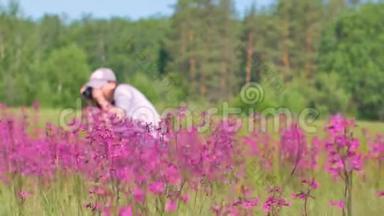 女人在花田里拍照。 自然学家或昆虫学家