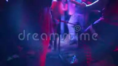 特写照片，年轻的时髦女人腿和红色吉他在霓虹灯。 摇滚<strong>音乐</strong>家在弹电吉他。