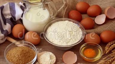 准备制作糕点的配料表。 鸡蛋，牛奶，面粉放在桌面上。 慢动作录像。
