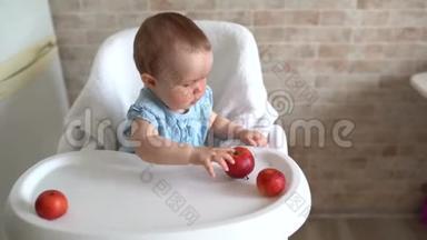 婴儿<strong>吃苹果</strong>。 可爱的小<strong>女孩</strong>在高椅子上<strong>吃</strong>和玩<strong>苹果</strong>。 可爱的孩子品尝水果。 健康饮食c
