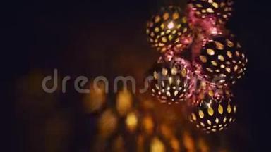 神奇的灯笼旋转，给墙壁以美丽的眩光。 双手握有发光二极管的新年发光球