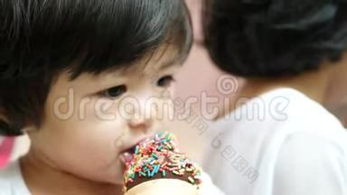 接近小亚洲女孩喜欢吃带有彩虹配料的巧克力冰淇淋-婴儿`的发展对他们的感觉
