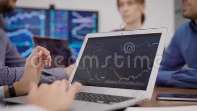 金融专家正在笔记本电脑屏幕上观看图表，在办公室的商务会议上<strong>翻动</strong>图片
