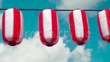东方纸红白灯笼乔钦挂在白色浑浊的蓝天背景上.. 日本挂的灯笼