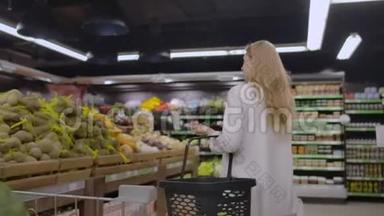 在<strong>超市</strong>里：美丽的年轻女子走过新鲜的农产品，选择<strong>蔬菜</strong>并把它们放进她的身体里
