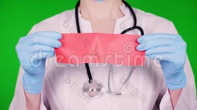 绿色背景。 特写镜头，医生穿着白色的医疗制服，用听诊器，双手用蓝色的医疗器械。