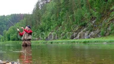 <strong>去钓鱼</strong>。 一个穿着红色衣服的有经验的渔夫站在水里。 山河。 一个留着胡子的人，看起来像萨