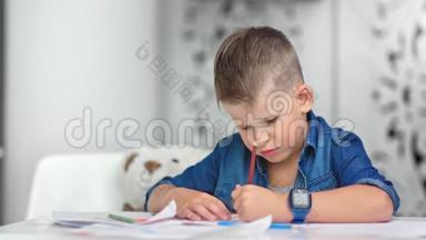 时尚自信的男孩在课桌上画纸，周围是教室白色的内部