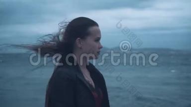 暴风<strong>雨中</strong>海边一个穿着自行车夹克的长发女孩的肖像。 阴天又冷，大海在暴风<strong>雨中</strong>。