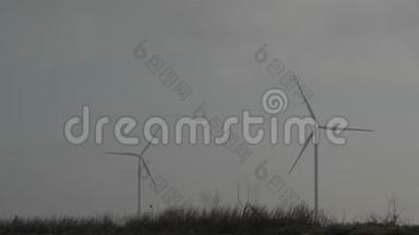 两个旋转风力<strong>发电机</strong>对抗灰色天空。 风的力量。 清洁和<strong>可</strong>再生能源解决方案。 风力涡轮机。