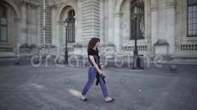 一个年轻漂亮的女人，黑发，穿着牛仔裤和黑色T恤，穿过巴黎。 <strong>实时</strong>宽镜头..