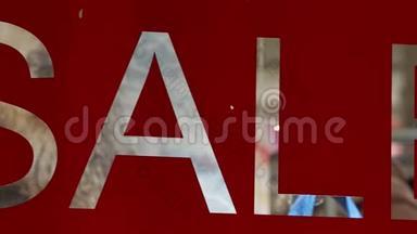 红色乙烯基贴花，在商店橱窗的玻璃上贴上文字销售。 符号反演