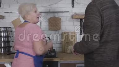 在厨房做饭的<strong>时候</strong>，一位年长的金发<strong>白种人</strong>女人拿着一束黄色郁金香。 成熟的丈夫