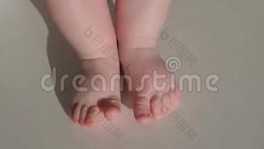 幼儿赤脚。 宝贝第一步。 白色背景的新生婴儿腿。 新的生活观念。 第一步背景