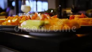 桌子的垂直全景，有盘子的食物，盘子上的蔬菜切片红色西红柿和黄瓜