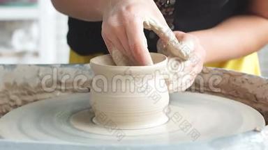 创造了一个<strong>陶罐</strong>。 波特。 粘土作坊。 装置上的粘土。 手在陶轮上工作，塑造一个<strong>陶罐</strong>
