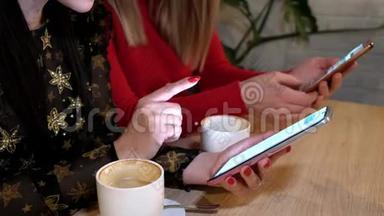 两个年轻女孩在咖啡厅使用智能手机无线浏览社交网络。