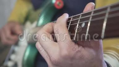 一位吉他大师的特写镜头`他的手滑在脖子上，用<strong>金属</strong>绿色老式电动演奏和<strong>弦</strong>、音阶和独奏