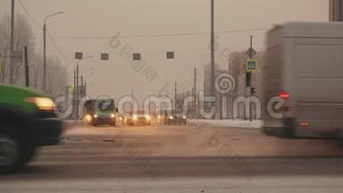 冬城雪道路口的汽车和公共汽车。 汽车在城市的雪道上行驶。 冬季越野