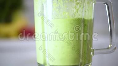 女人在玻璃上倒健康的绿色冰沙。 排毒和健康生活理念.. 素食，素食