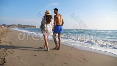 一对情侣在海边<strong>散步</strong>，在度假胜地休息时<strong>牵手</strong>。 男人拥抱女人漫步在海滩上